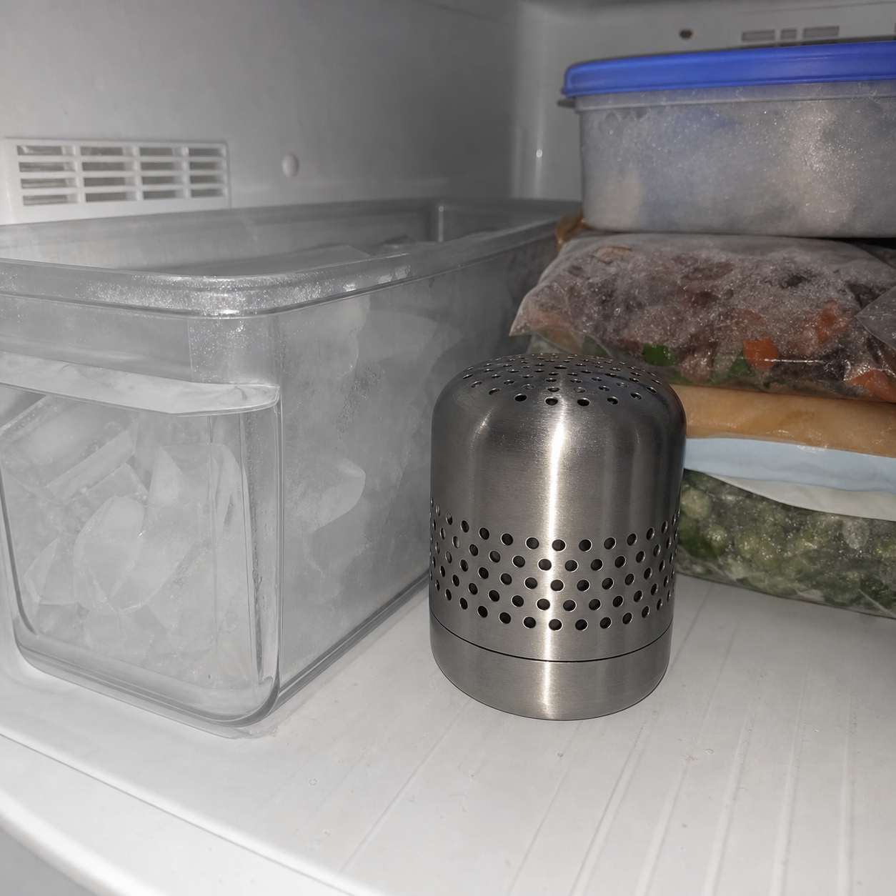 Kursi deodorizer positioned beside a freezer ice bin and frozen food